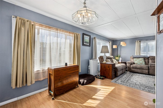 living room featuring an inviting chandelier, a healthy amount of sunlight, and wood-type flooring