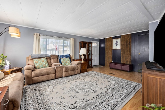 living room with light wood-type flooring and ornamental molding