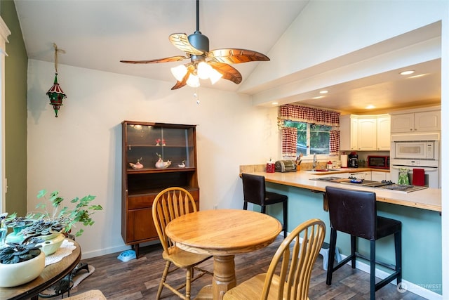 dining area with dark hardwood / wood-style floors, vaulted ceiling, ceiling fan, and sink