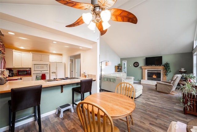 dining area featuring ceiling fan, dark hardwood / wood-style floors, and lofted ceiling