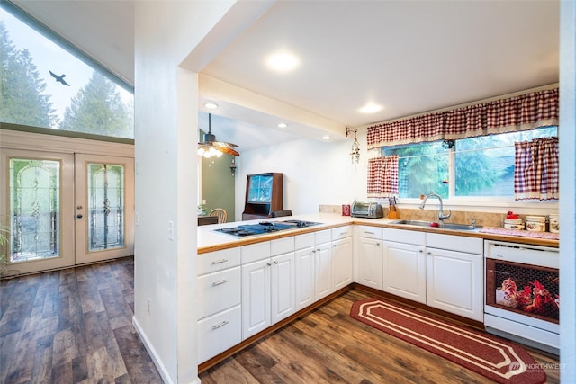 kitchen featuring white gas stovetop, dishwashing machine, sink, white cabinetry, and hanging light fixtures