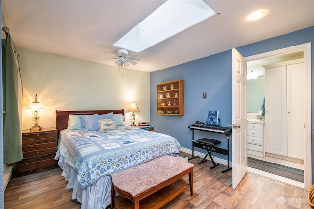 bedroom featuring ceiling fan, wood-type flooring, and ensuite bath