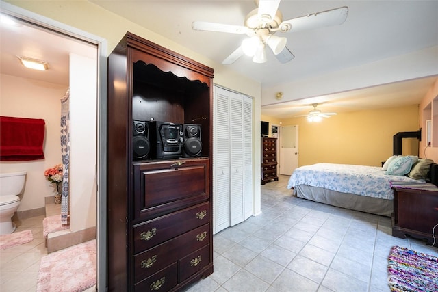 bedroom with connected bathroom, ceiling fan, a closet, and light tile patterned floors