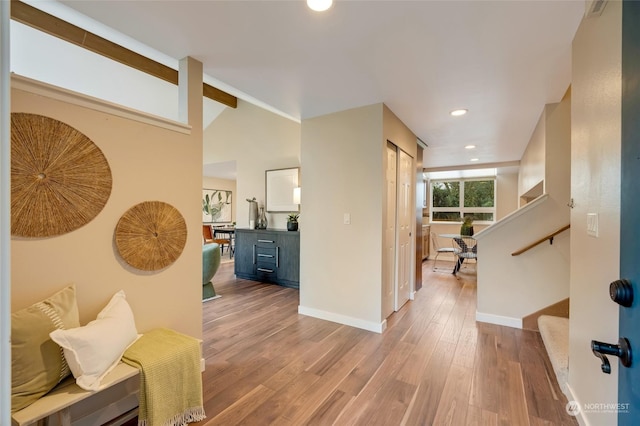 hall featuring high vaulted ceiling and hardwood / wood-style floors