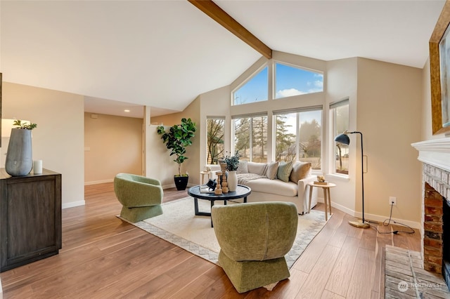 living room with a brick fireplace, light wood-type flooring, beam ceiling, and high vaulted ceiling