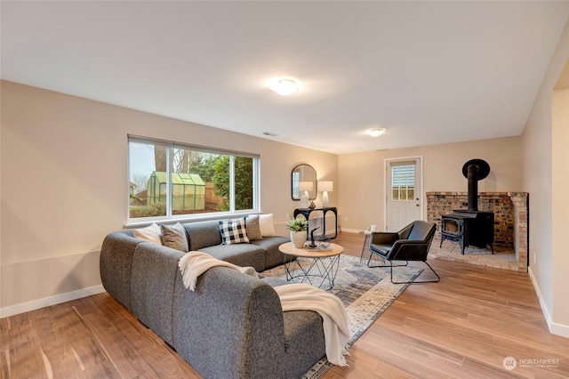 living room with light hardwood / wood-style flooring and a wood stove