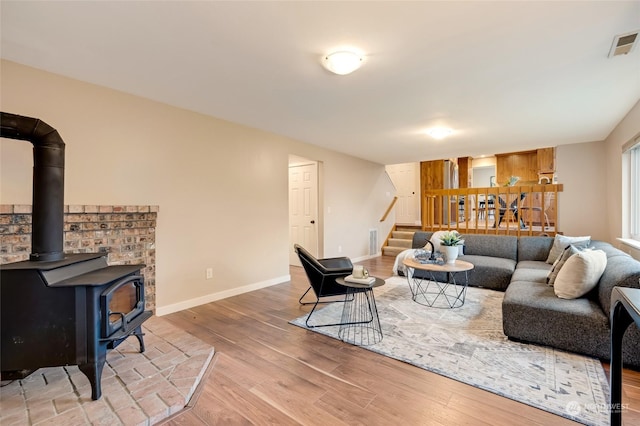 living room with light hardwood / wood-style floors and a wood stove