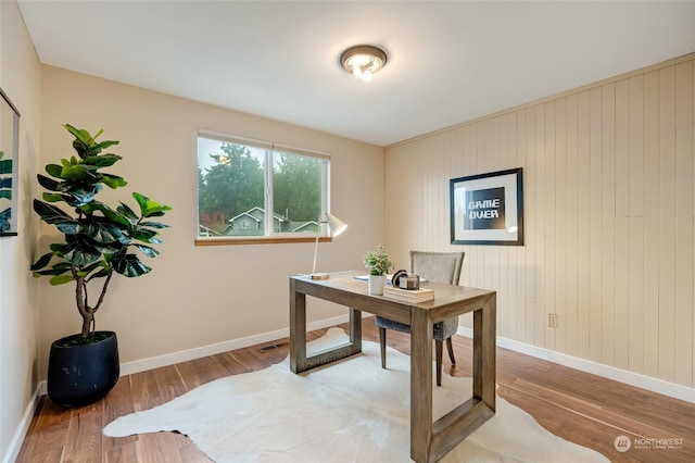 office featuring wooden walls and wood-type flooring