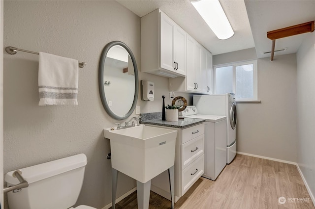 clothes washing area featuring washer and dryer and light hardwood / wood-style flooring