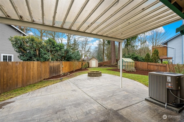 view of patio / terrace featuring a fire pit, cooling unit, and a storage unit