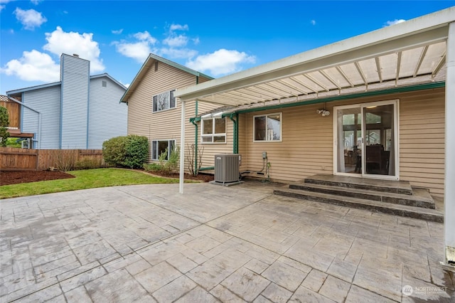 rear view of house featuring a patio, central AC, and a yard