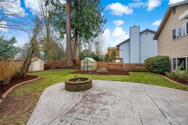 view of patio with an outdoor fire pit and a shed