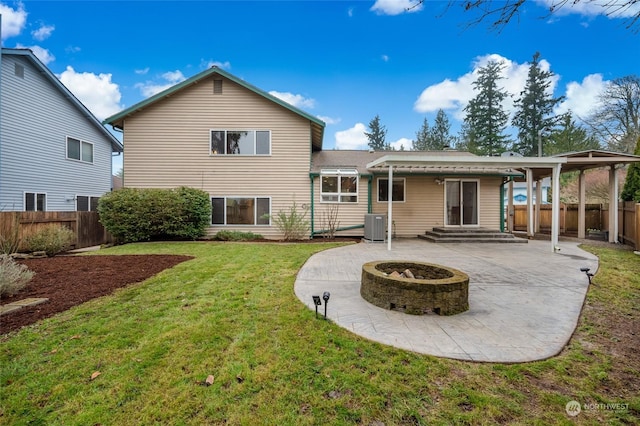 rear view of house with an outdoor fire pit, a patio area, central AC unit, and a lawn