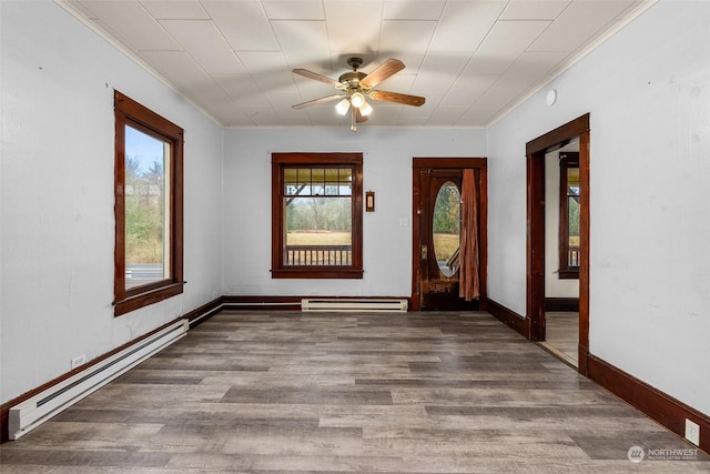 foyer featuring baseboard heating, ceiling fan, and a healthy amount of sunlight