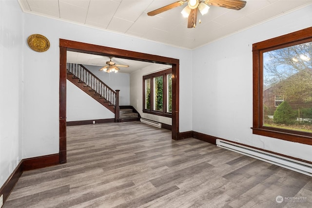 spare room featuring ornamental molding, a baseboard radiator, ceiling fan, and hardwood / wood-style flooring