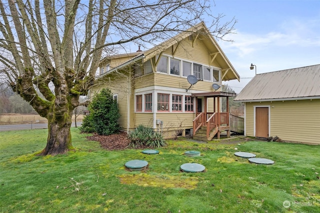 back of house with a sunroom and a yard