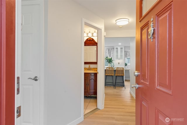 hall with sink and light hardwood / wood-style flooring