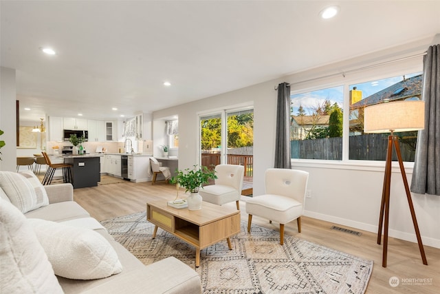 living room with beverage cooler and light hardwood / wood-style floors