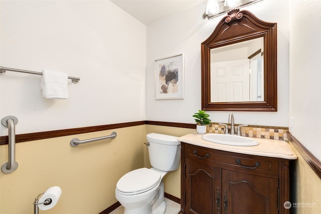 bathroom featuring vanity, decorative backsplash, and toilet