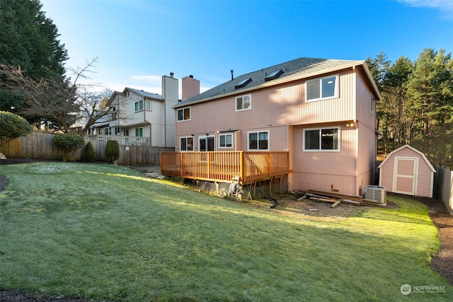 rear view of property with a shed, a wooden deck, and a lawn