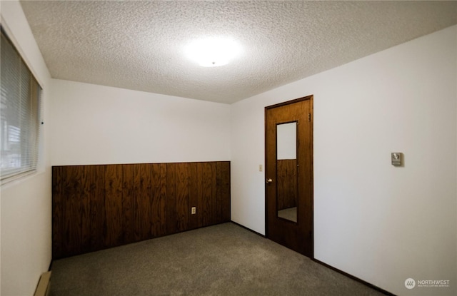 unfurnished room with light carpet and a textured ceiling