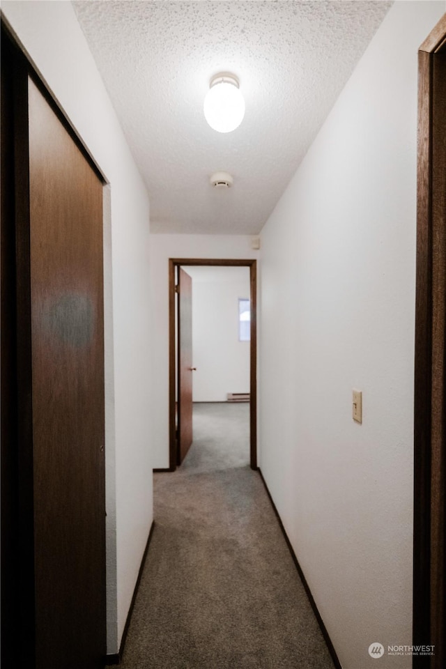 hall with carpet and a textured ceiling