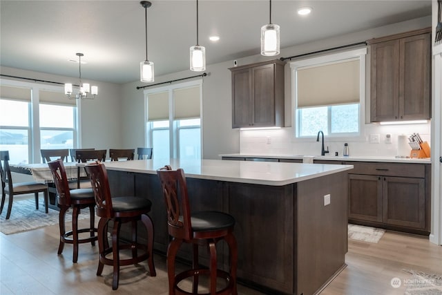 kitchen with tasteful backsplash, hanging light fixtures, and a kitchen island