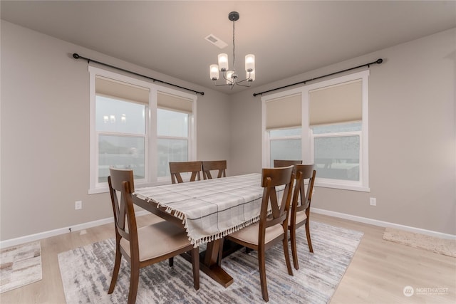 dining area with an inviting chandelier and light wood-type flooring