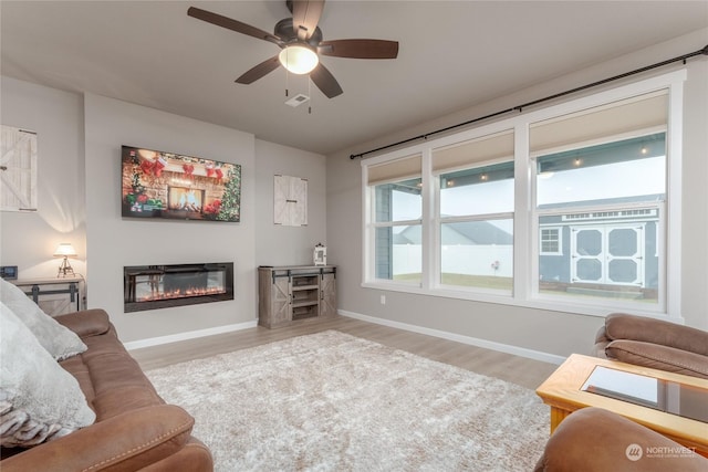 living room with light hardwood / wood-style floors and ceiling fan