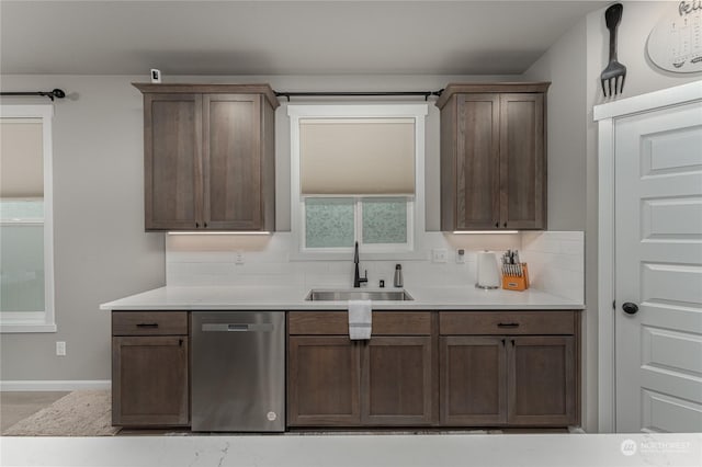 kitchen featuring tasteful backsplash, stainless steel dishwasher, light hardwood / wood-style floors, and sink