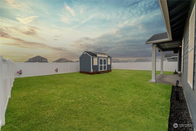 yard at dusk featuring a patio and a storage shed