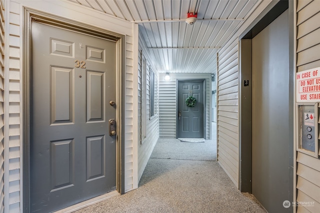 interior space with carpet floors and wood walls