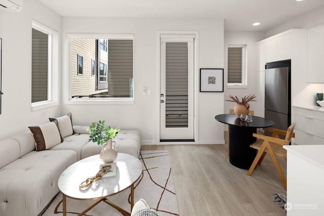 living room with light wood-type flooring and a wall unit AC