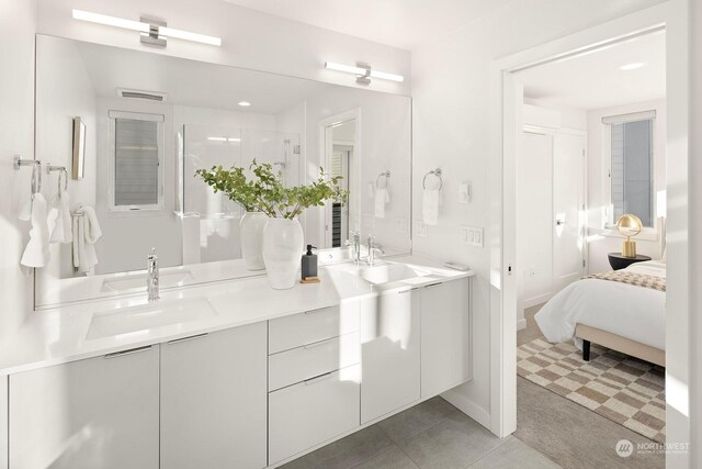 bathroom with tile patterned floors, vanity, and a shower with door