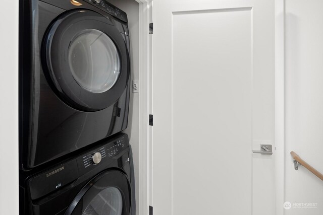 clothes washing area featuring stacked washer and clothes dryer