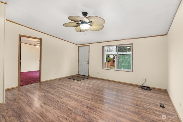 spare room featuring hardwood / wood-style floors, vaulted ceiling, ornamental molding, and ceiling fan