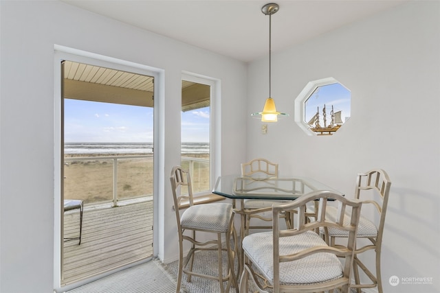 dining space featuring a water view and a beach view