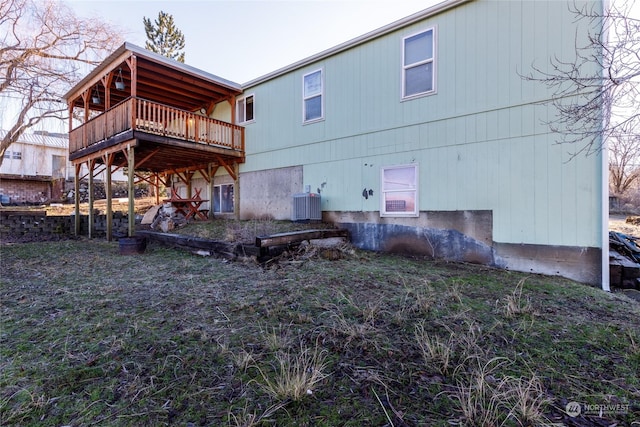 rear view of property featuring central air condition unit and a wooden deck