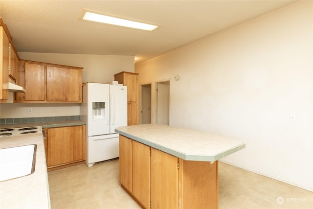 kitchen with a kitchen island, white fridge with ice dispenser, sink, and vaulted ceiling