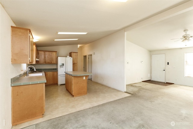 kitchen with ceiling fan, a center island, sink, white refrigerator with ice dispenser, and vaulted ceiling