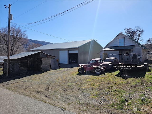 view of front of home featuring a garage, a mountain view, and an outdoor structure