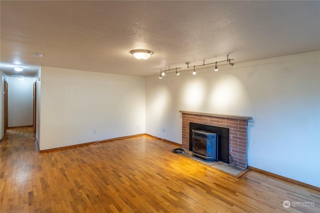 unfurnished living room with wood-type flooring and a textured ceiling