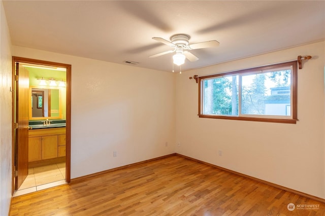 empty room featuring sink, light hardwood / wood-style floors, and ceiling fan