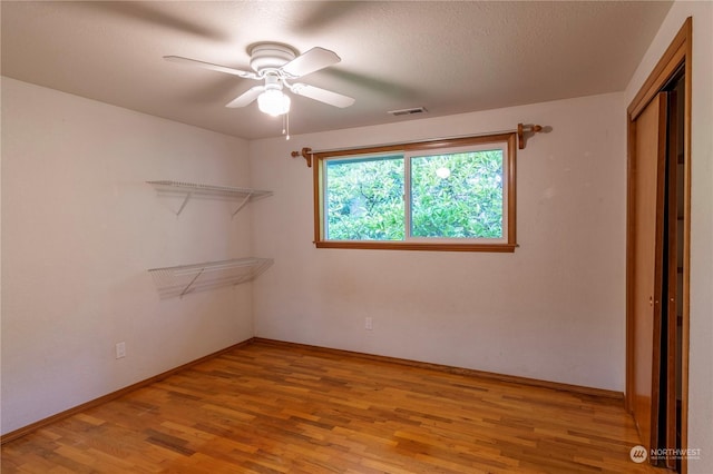 interior space with ceiling fan, light hardwood / wood-style floors, and a closet