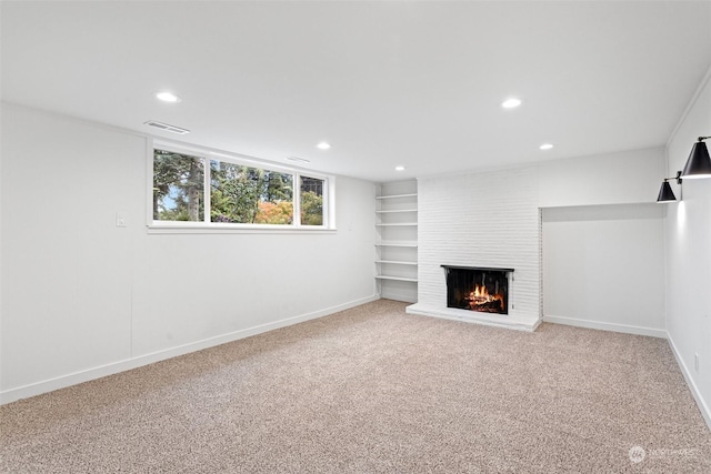 basement with carpet flooring and a large fireplace