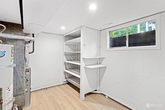 interior space with gas water heater and hardwood / wood-style flooring