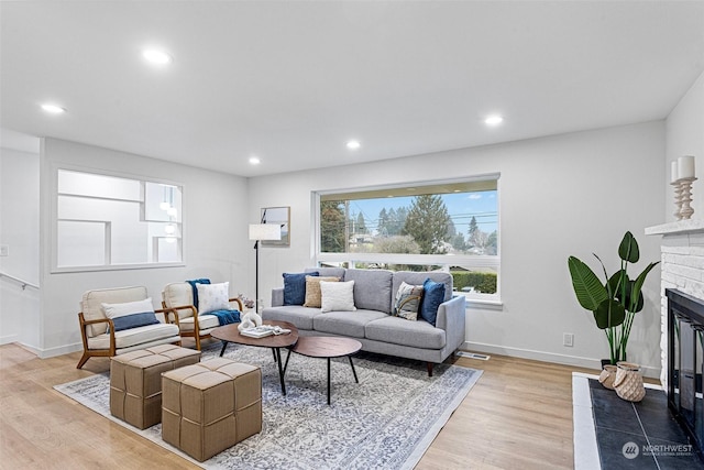 living room with light hardwood / wood-style floors and a fireplace