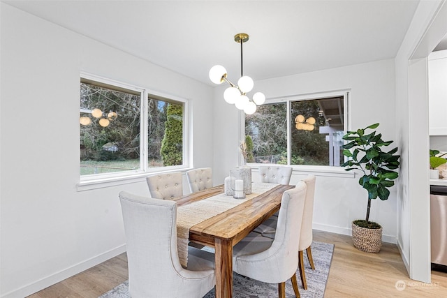 dining space with a notable chandelier and light wood-type flooring