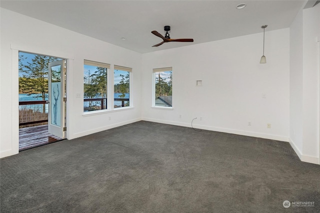 empty room featuring dark colored carpet and ceiling fan