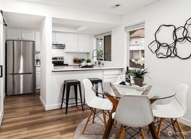 dining space with dark hardwood / wood-style flooring and sink